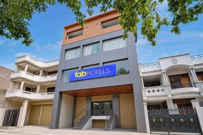 A modern hotel with a prominent sign, multiple balconies, and a staircase leading to the entrance. - Fabhotel South Town - Near Govindpuri Railway Junction (Kanpur)