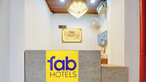 A hotel reception area with a 'fab hotels' sign, a chandelier, a framed artwork, and a television on the wall. - FabHotel Southtown - Near Govindpuri Railway Junction (Kanpur)