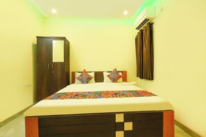 A bedroom with a bed, a wardrobe, and an air conditioning unit. - Via Onyx Residency (Bengaluru)