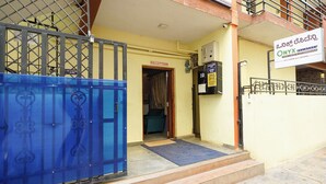 Ein Gebäudeeingang mit Empfangsbereich, einem blauen Tor und einem Schild mit der Aufschrift 'Lodge & Guest House Accommodation'.