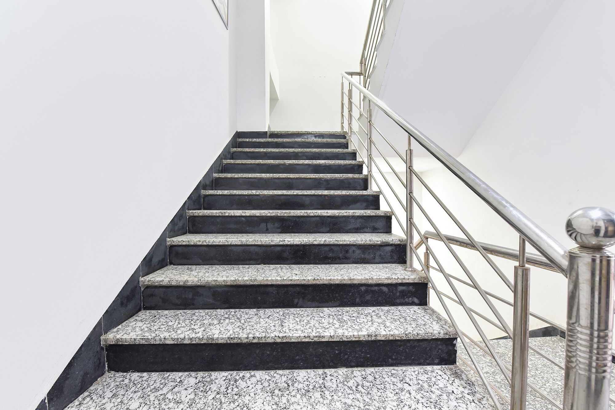 Una escalera de granito con barandales de metal.