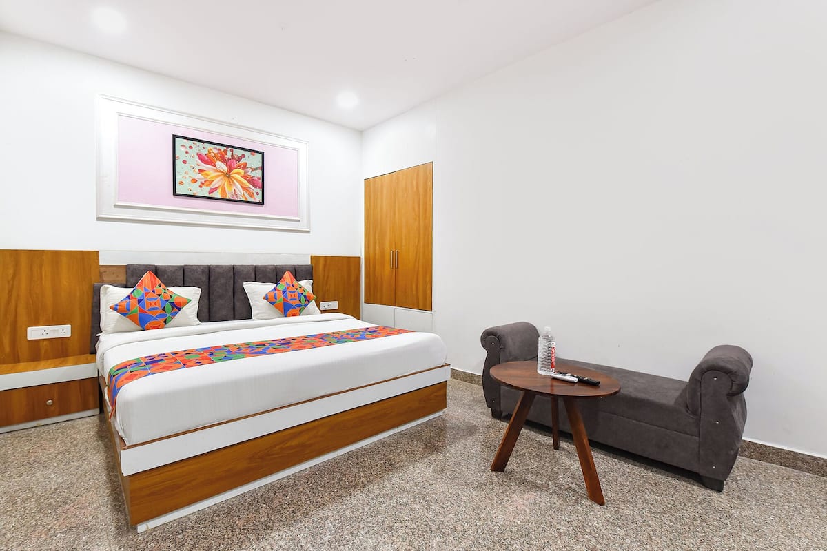Ein Hotelzimmer mit einem Bett, einem kleinen Tisch, einer Couch und einem Bild an der Wand.