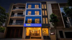 Um edifício moderno com uma placa indicando 'fab hotels' e uma placa de identificação com o nome 'MARUTI'.