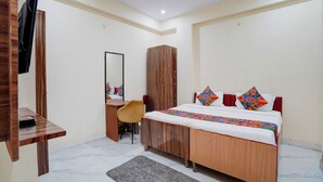 A bedroom with a bed, a wardrobe, a desk, and a chair. - Fabhotel Rv (Noida)