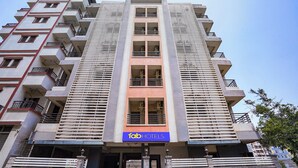 Un hotel de varios pisos con balcones, una entrada central y un letrero que dice 'fabHOTELS'.