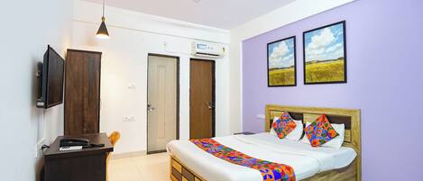 Un dormitorio con cama, escritorio, silla, ventilador de techo y dos puertas.
