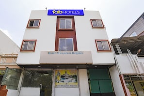 Un edificio con un letrero que dice 'Hotel Manjulam Regency' y un letrero de 'fabHOTELS' encima.