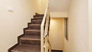Una escalera con barandilla, un interruptor de luz y un perchero en la pared.