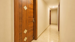 Un pasillo con puertas de madera y suelo de baldosas.