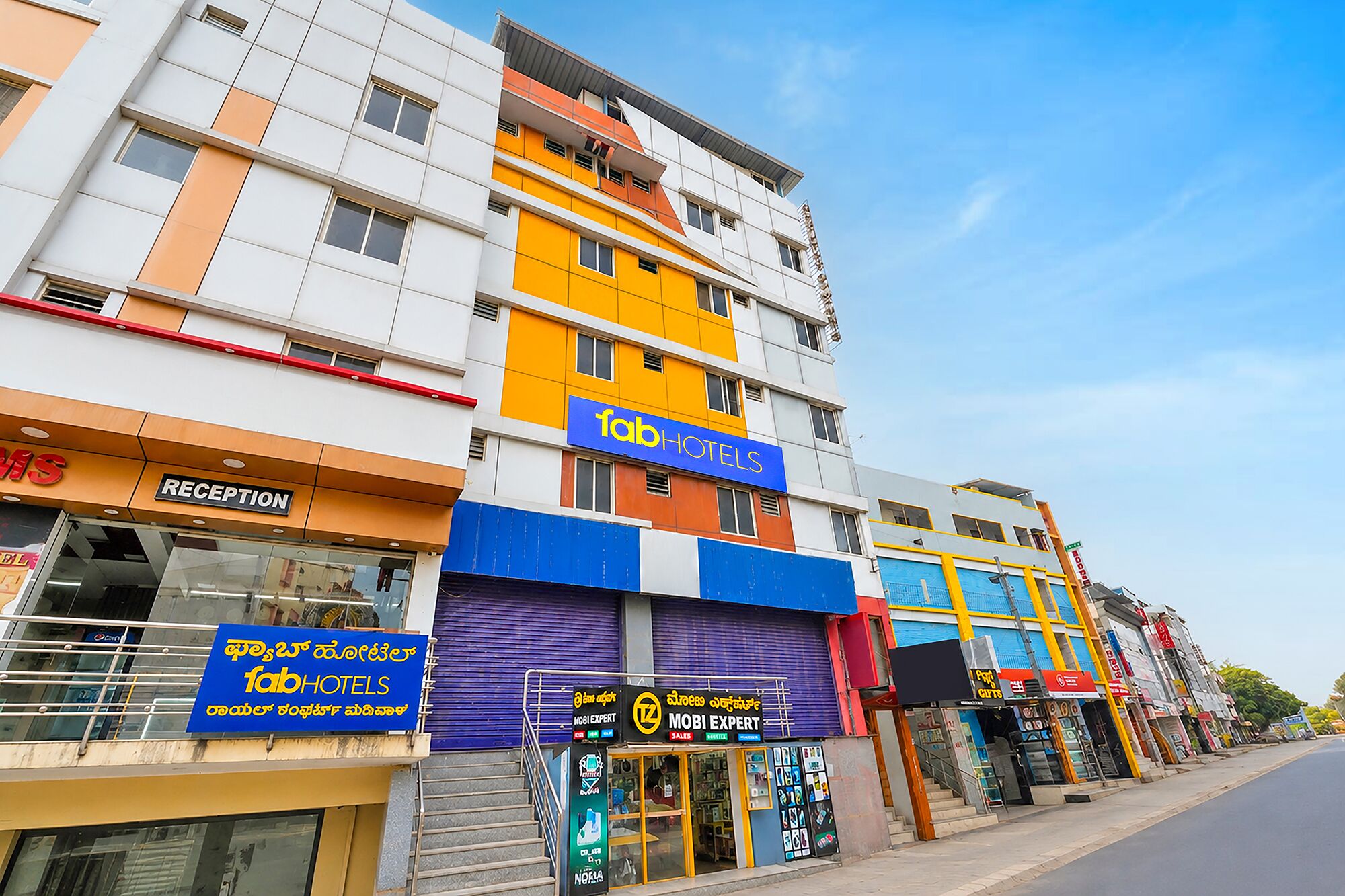 A multi-story hotel with a reception area, a mobile expert shop, and a visible staircase.