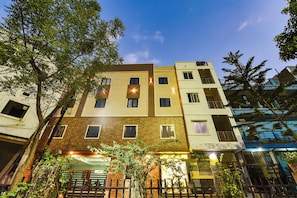 Un edificio de varios pisos con fachada de ladrillo, varias ventanas y balcones.