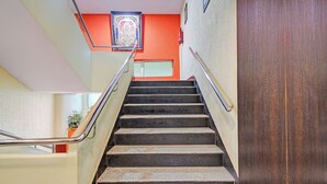 Eine Treppe mit Metallgeländern, einem Feuerlöscher und einer Tür auf der rechten Seite.