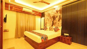 Quarto moderno com cama, ventoinha no teto, ar condicionado e decoração na parede.