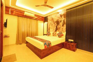 Un dormitorio moderno con cama, ventilador de techo, equipo de aire acondicionado y un detalle decorativo en la pared.