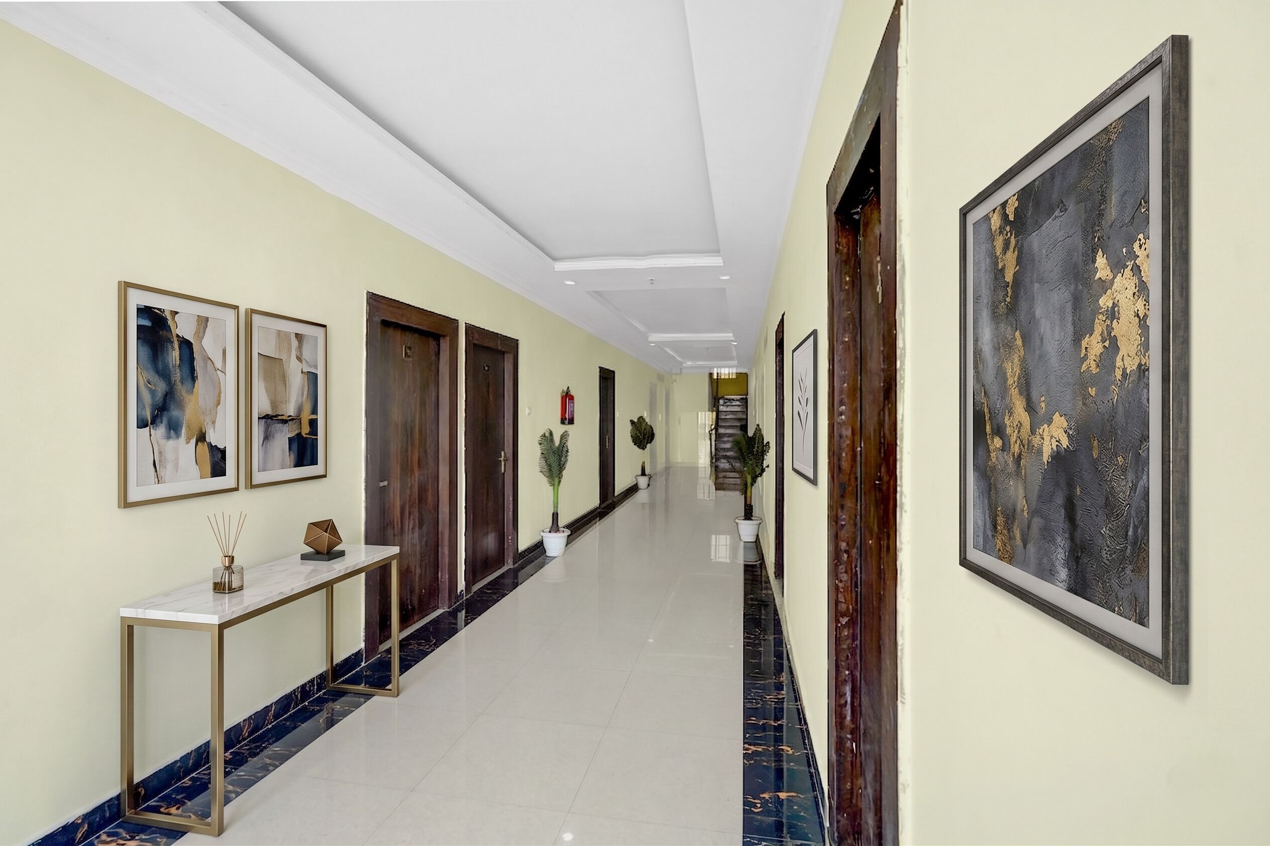 A hallway with framed artwork, a marble-tiled floor, and potted plants.