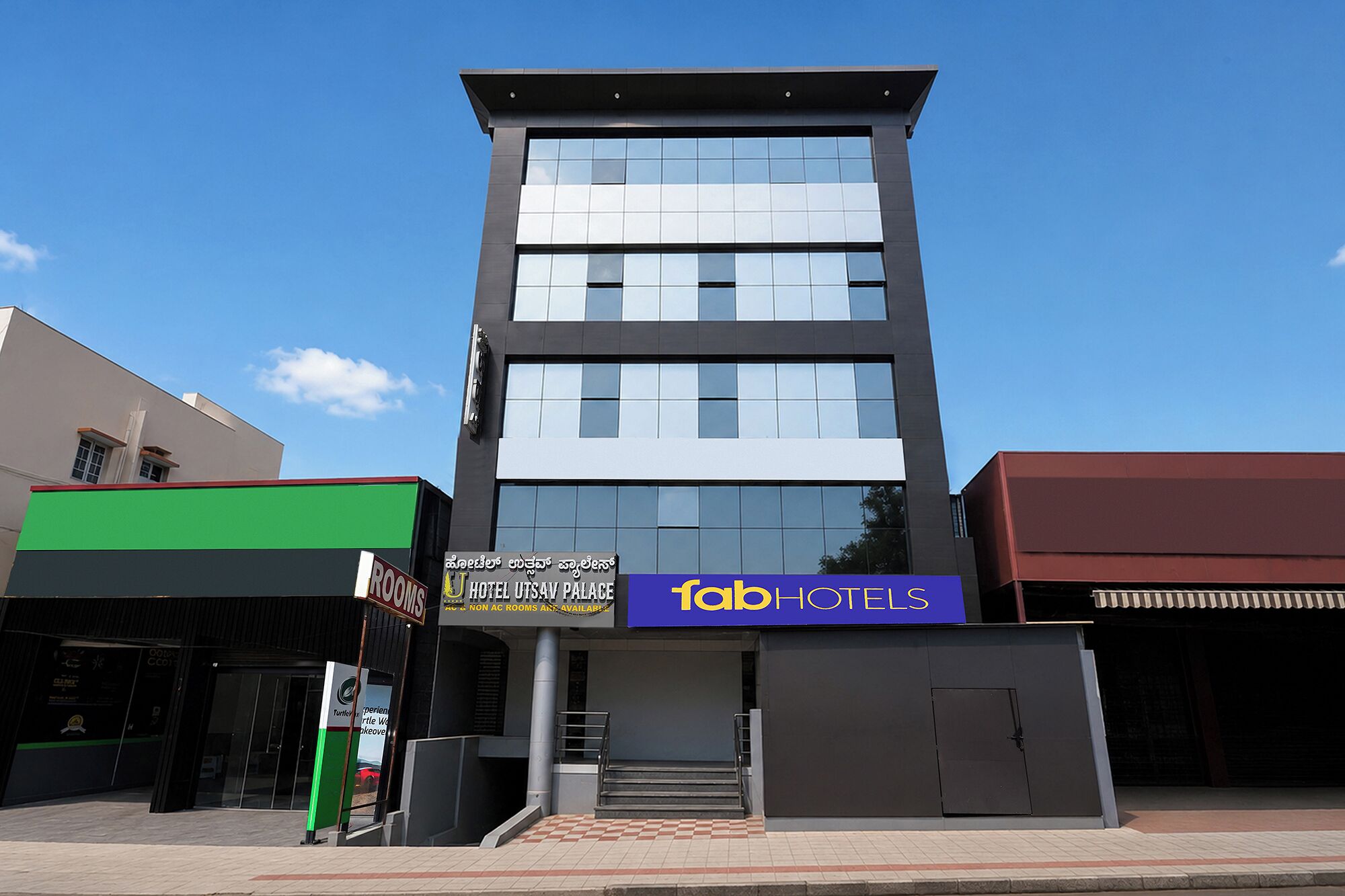 Un moderno edificio de hotel con un cartel que dice 'fab hotels' y un cartel que dice 'HOTEL UTSAV PALACE'.