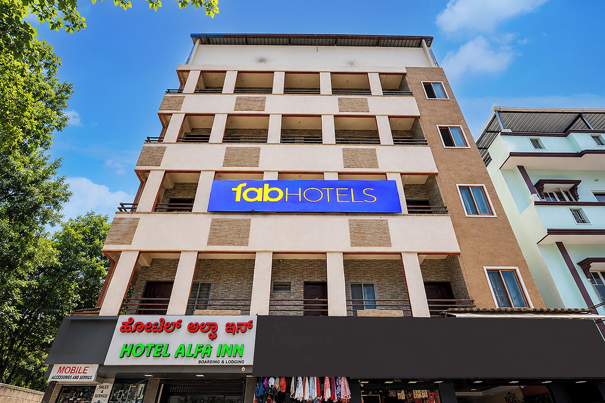 Un edificio de varios pisos con un llamativo letrero de 'fab hotels'.