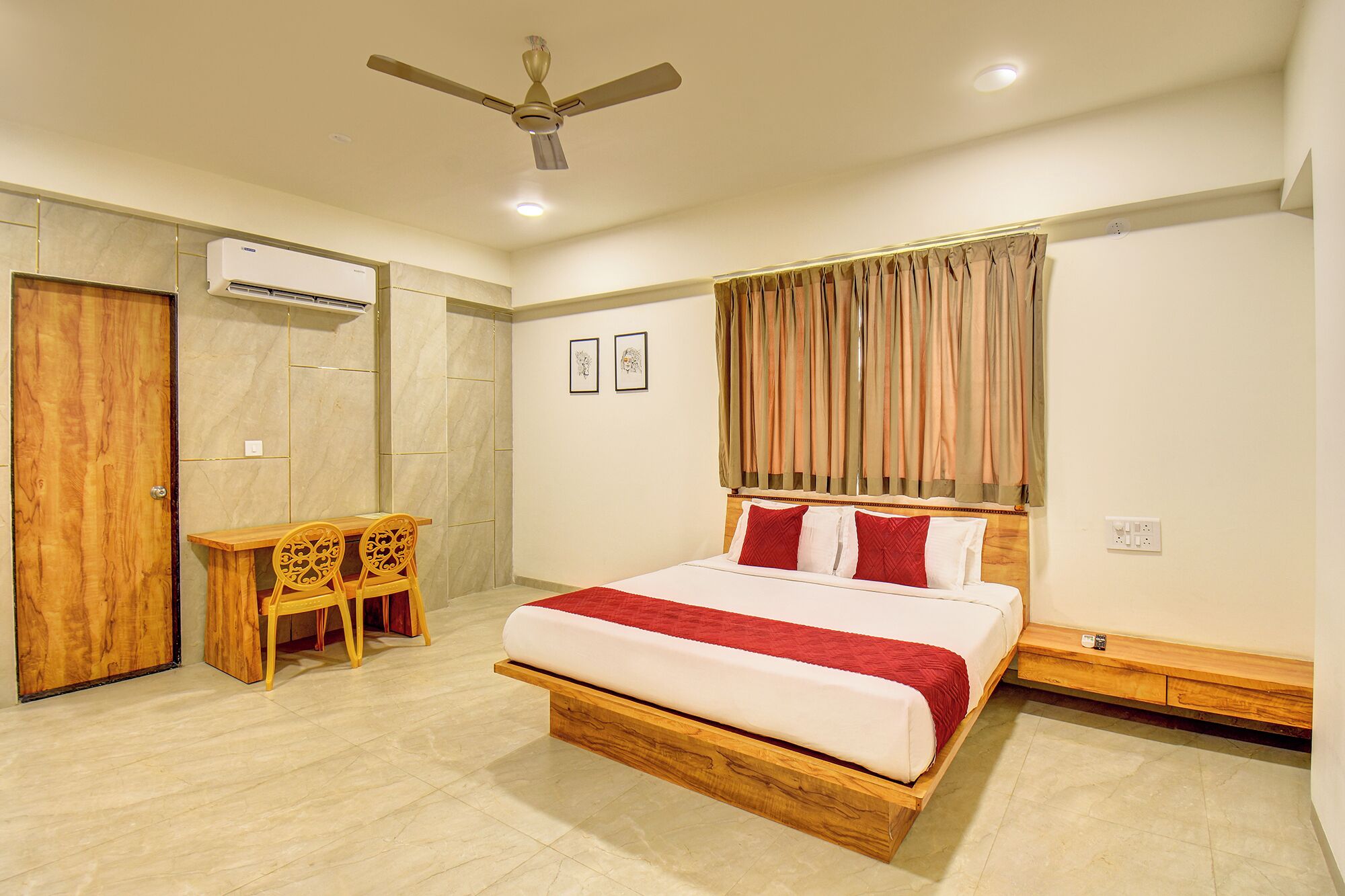 A bedroom with a bed, a desk, a chair, an air conditioner, a ceiling fan, and a window with curtains.
