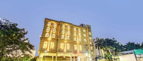 Un hotel de varios pisos con ventanas iluminadas y una entrada central.