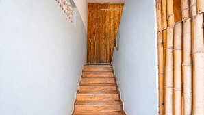 A wooden staircase leading to a room with a bamboo curtain. - Fabhotel Moon Stay - Nr Urappakkam Railway Station (Chennai)
