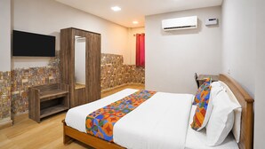 A bedroom with a bed, a wardrobe, a television, an air conditioning unit, and a shower area. - Fabhotel Moon Stay - Nr Urappakkam Railway Station (Chennai)