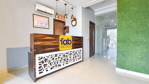 A reception desk with a wooden finish, a 'fab hotels' sign, and a decorative wall panel. - FabHotel Blue Diamond - Mansarovar , Jaipur (Jaipur)