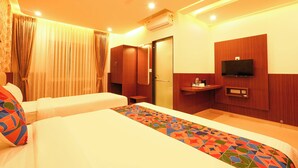 Ein Hotelzimmer mit Bett, Fernseher, Schreibtisch und Klimaanlage.