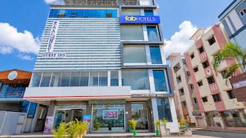 A hotel with a modern design, including a prominent 'fabHOTELS' sign, a guest inn label, and a function hall.