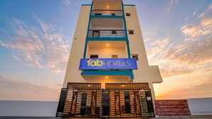A multi-story building with a sign reading 'fabHOTELS' at the entrance.