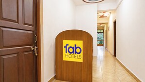 Un couloir d’hôtel avec une porte en bois et une enseigne indiquant « fab hotels ».