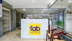 Ein Empfangsschalter mit Marmorplatte und einem gelben Schild mit der Aufschrift 'fab hotels'.