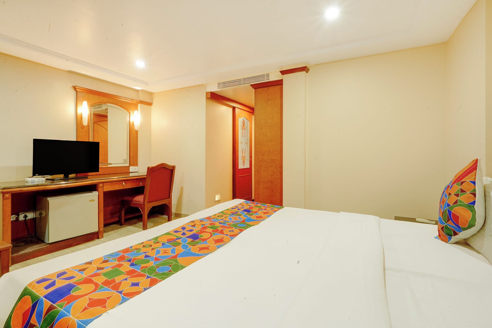 Une chambre d’hôtel comprenant un lit, un bureau avec un ordinateur, une chaise et un téléviseur.