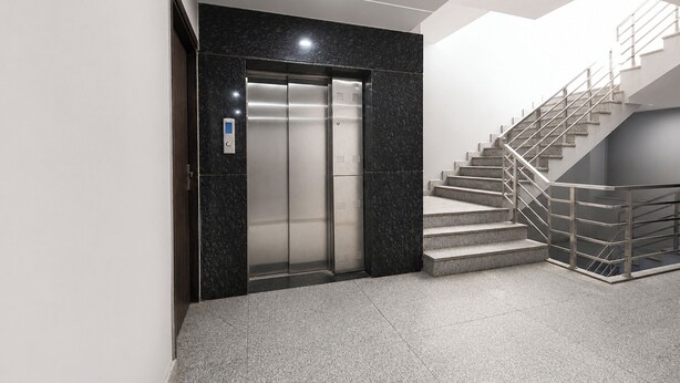 An elevator, a staircase with metal railings, and a patterned floor. - FabHotel A V Homes - Navjeevan Hospital & Maternity Centre (Gurugram)