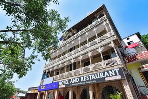Monikerroksinen hotelli, jossa on koristeelliset parvekkeet ja kyltti, jossa lukee: »Hotelli ja ravintola AC Rooms».