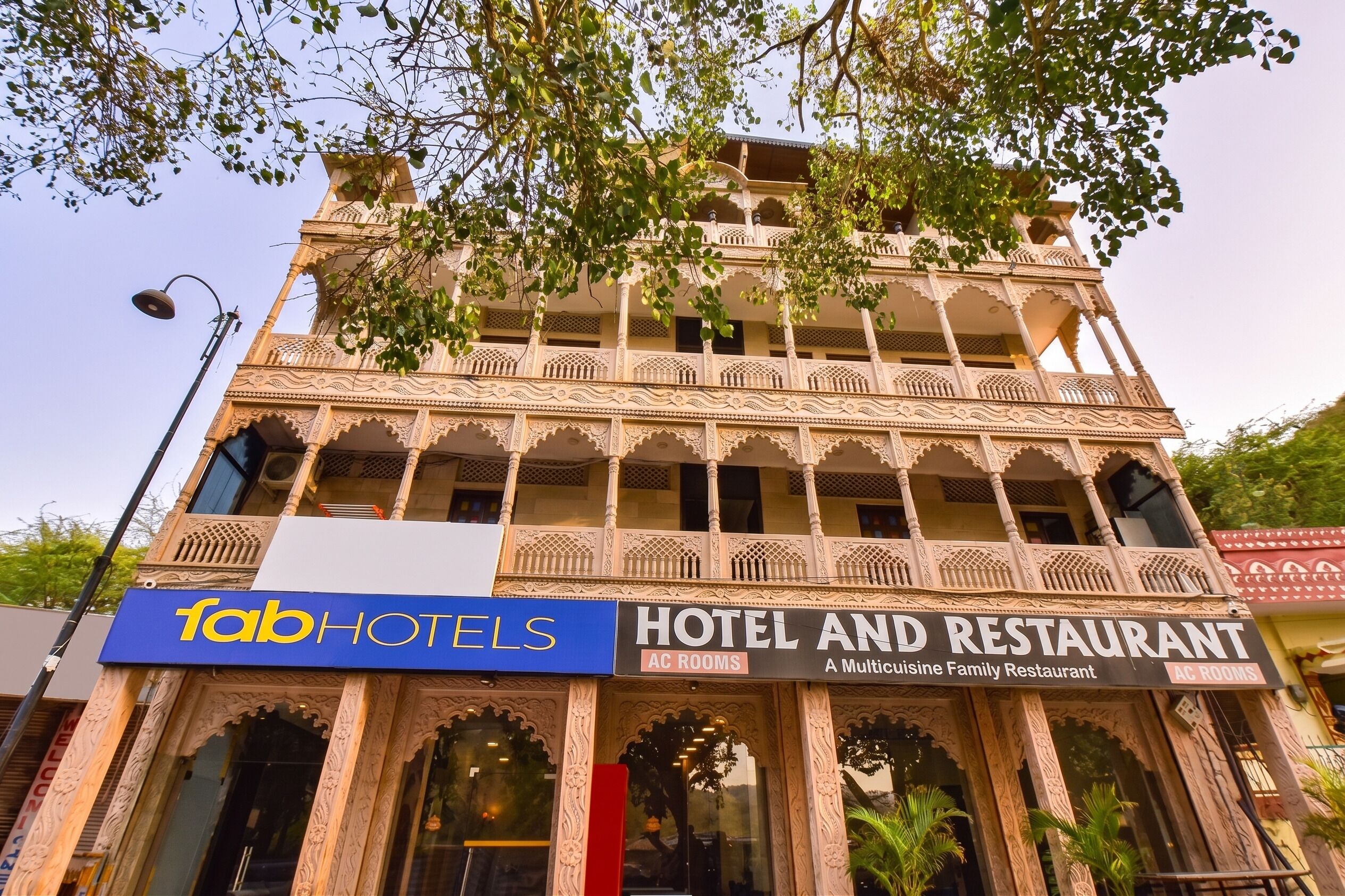 Un edificio con un letrero que indica 'fabHOTELS' y 'HOTEL Y RESTAURANTE', mostrando un establecimiento ideal para familias con varias habitaciones.
