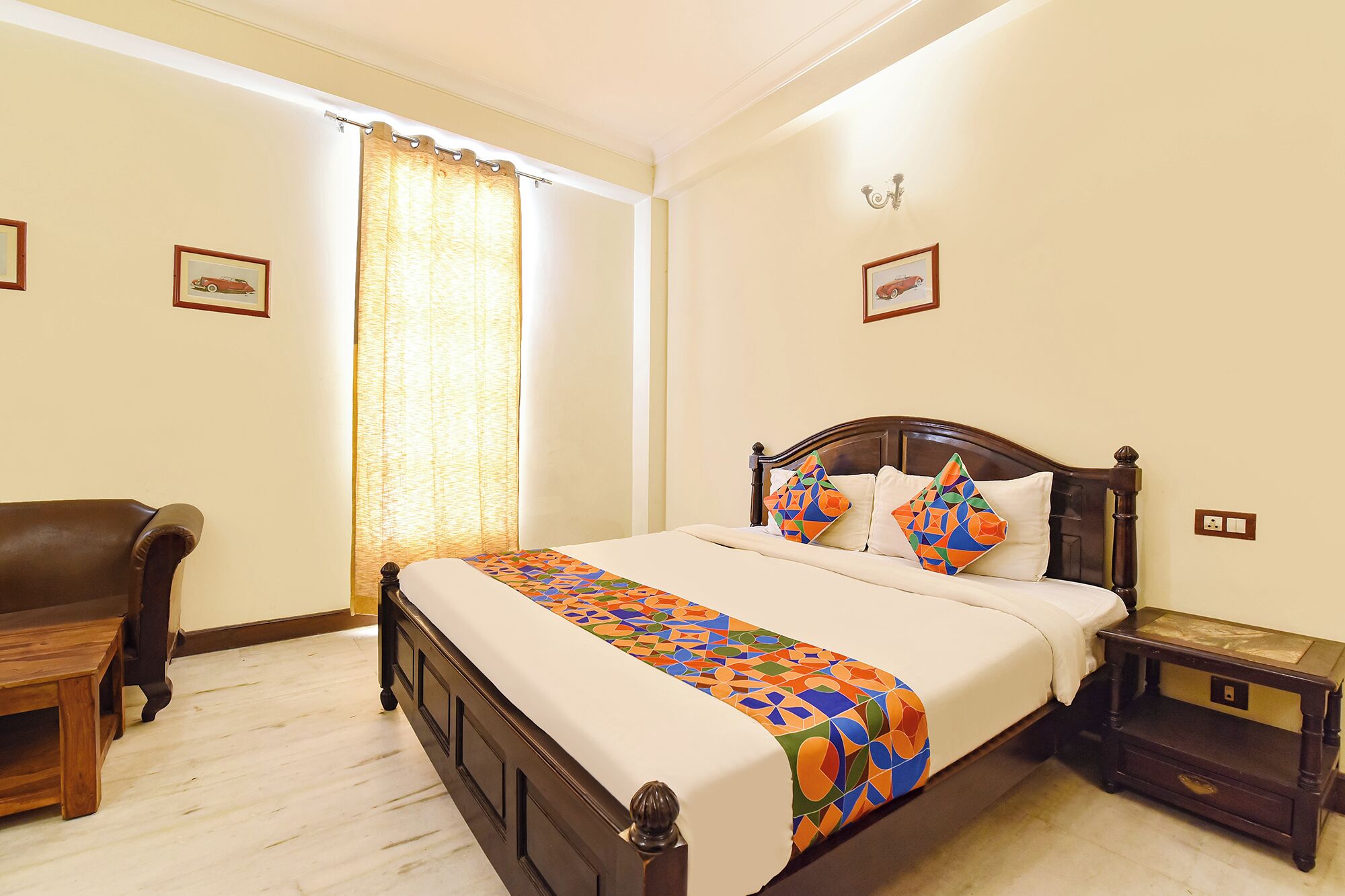 A neatly arranged bedroom with a bed, a chair, a nightstand, and a window with curtains.