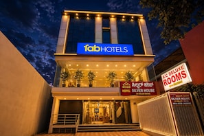 A modern building with a sign for fab hotels. There are potted plants on the balcony, and a staircase leading to the entrance. - FabHotel Silver House Inn (Bangalore)