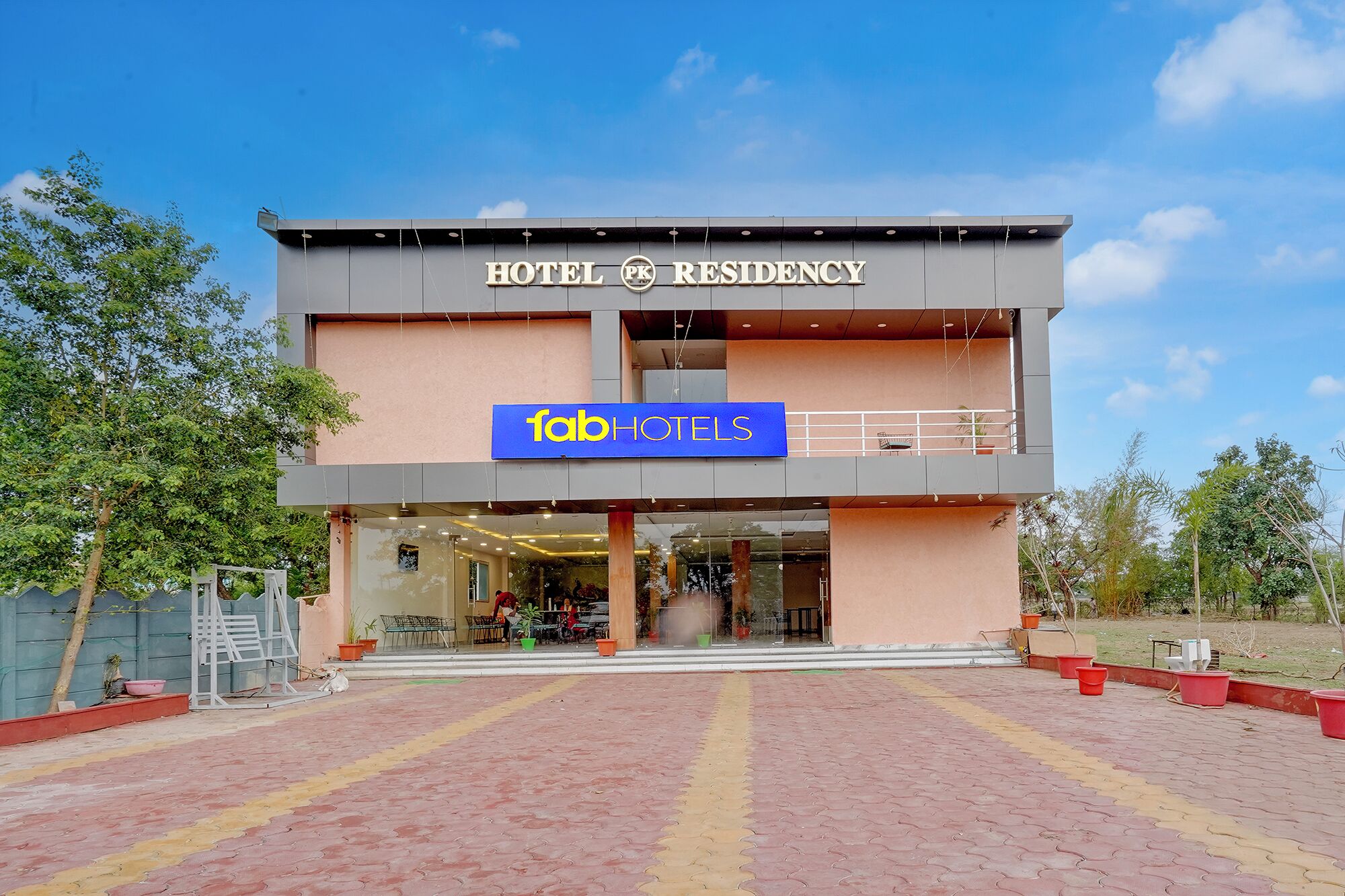 A hotel with a modern facade, a sign for 'fabHOTELS,' and a visible entrance.