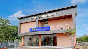 Ett modernt hotell med en skylt på fasaden där det står ”HOTEL RESIDENCY” och ”fabHOTELS”.