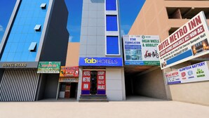 Un hôtel doté d’une façade moderne, de nombreuses enseignes publicitaires pour différents services et d’une entrée bien visible.