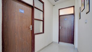 Un couloir avec deux portes en bois, chacune portant un numéro.