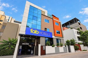 A multi-story hotel building with a prominent 'fabHOTELS' sign, a 'SMART PRO ZONE' entrance, and a modern architectural design. - FabHotel La Banian (Indore)