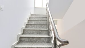 A staircase with granite steps and a metal handrail. - Via Dazling Studio (Pune)