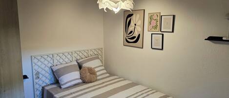 Tabla de planchar con plancha y ropa de cama