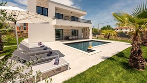 A modern two-story house with a swimming pool, outdoor seating, and a well-maintained lawn. - Villa Kri to Zadarvillas (Privlaka)