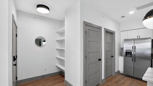 Eine moderne Küche mit weißen Schränken, einem Edelstahlkühlschrank und einem Holzboden.
