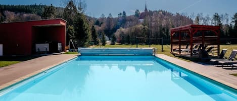 Una piscina techada, una piscina al aire libre de temporada, sombrillas