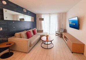 Een moderne woonkamer met een bank, een salontafel, een televisie en een kunstwerk aan de muur.