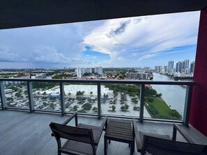 A balcony with a view of a cityscape, including buildings and a river. - City View Getaway  2BR Beachwalk Resort (Hallandale Beach)