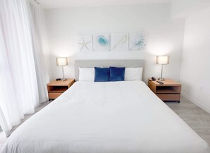 A hotel room with a large bed, two bedside tables, and a headboard. - City View Getaway  2BR Beachwalk Resort (Hallandale Beach)